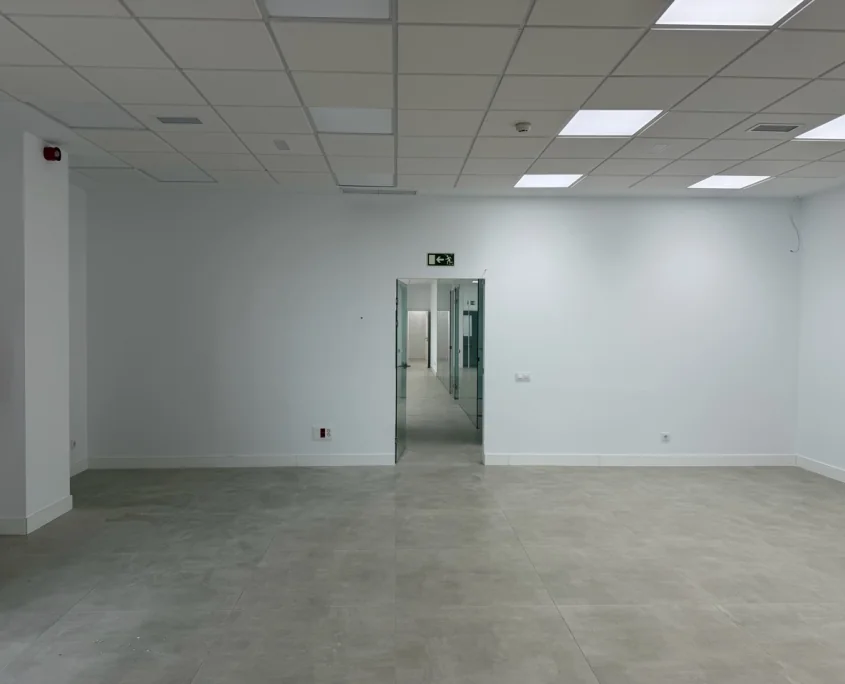 Oficina amplia con paredes interiores blancas tras un trabajo de pintura profesional.