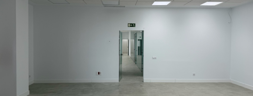 Oficina amplia con paredes interiores blancas tras un trabajo de pintura profesional.