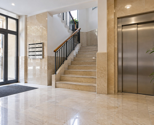 Portal limpio de una comunidad con escaleras y ascensor